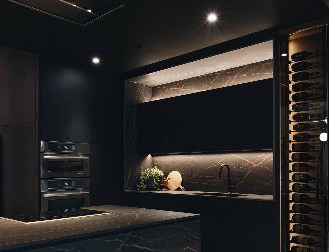 Cuisine sur mesure prestige avec îlot en marbre noir et or et cellier à vin intégré, projet Groupe Cartier