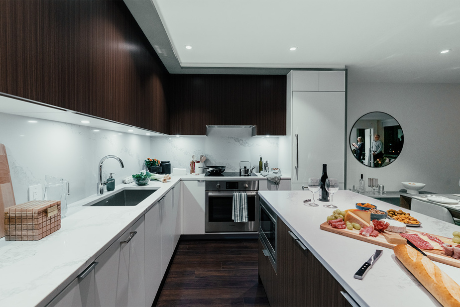 Cuisine sur mesure en ébénisterie de bois foncé et armoires blanches avec comptoir en quartz, Le Cartier, Montréal