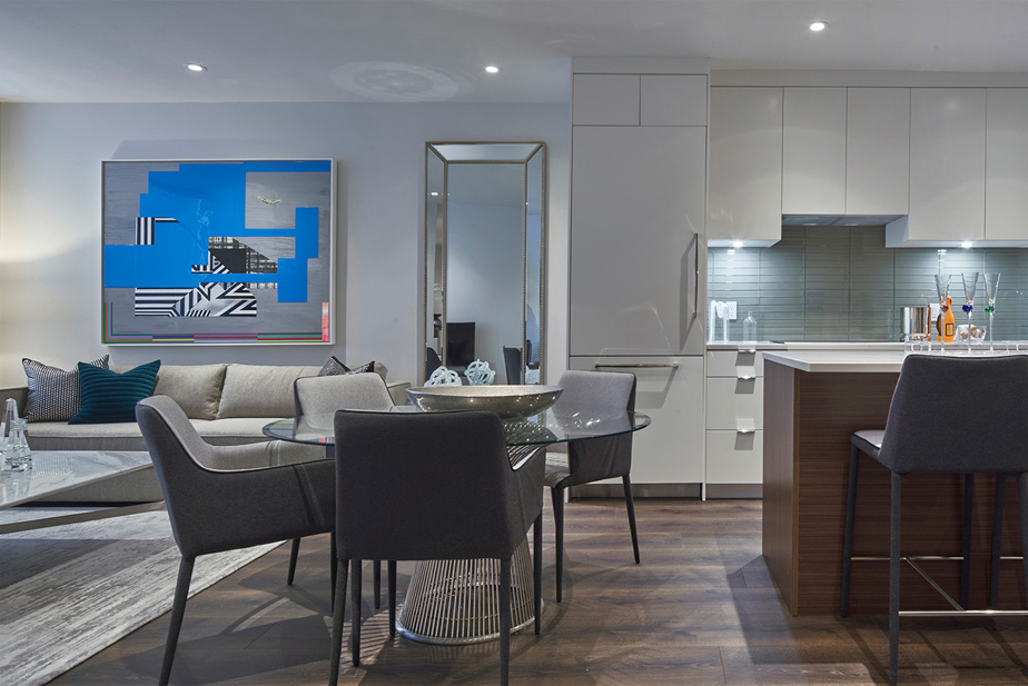 Cuisine ouverte sur le salon avec îlot en bois et armoires blanches, Le Cartier, Montréal