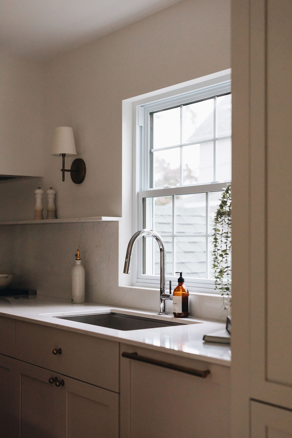 Évier sous fenêtre et comptoir de quartz dans une cuisine sur mesure à Boucherville
