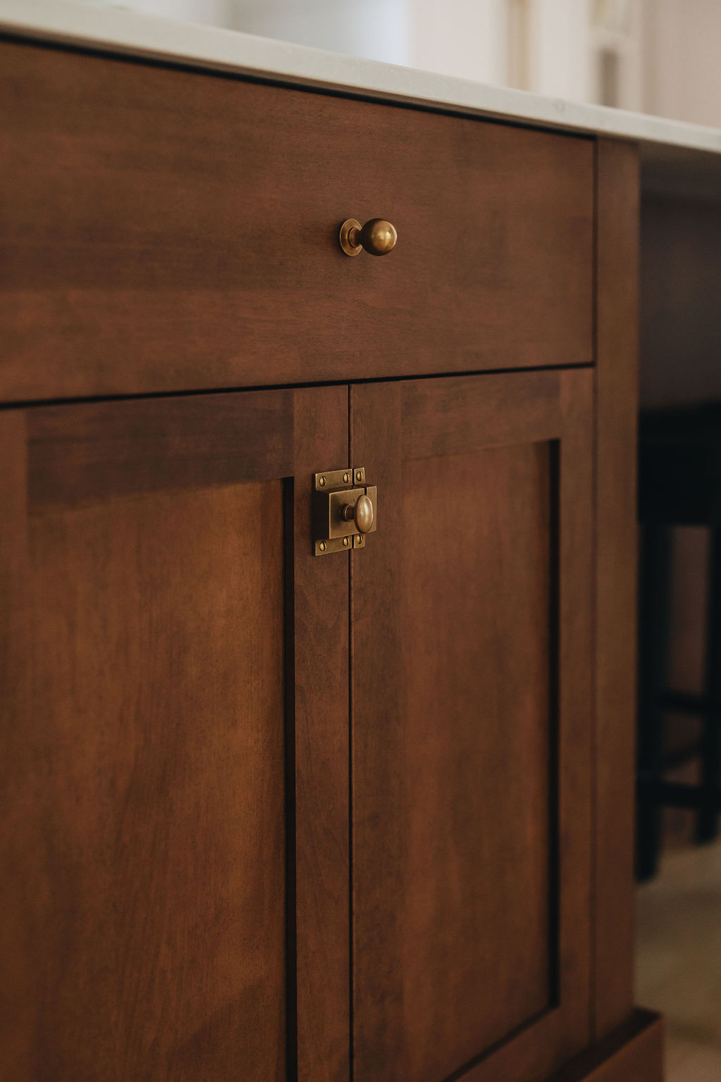 Tiroir et porte d’armoire en bois foncé avec poignées en laiton