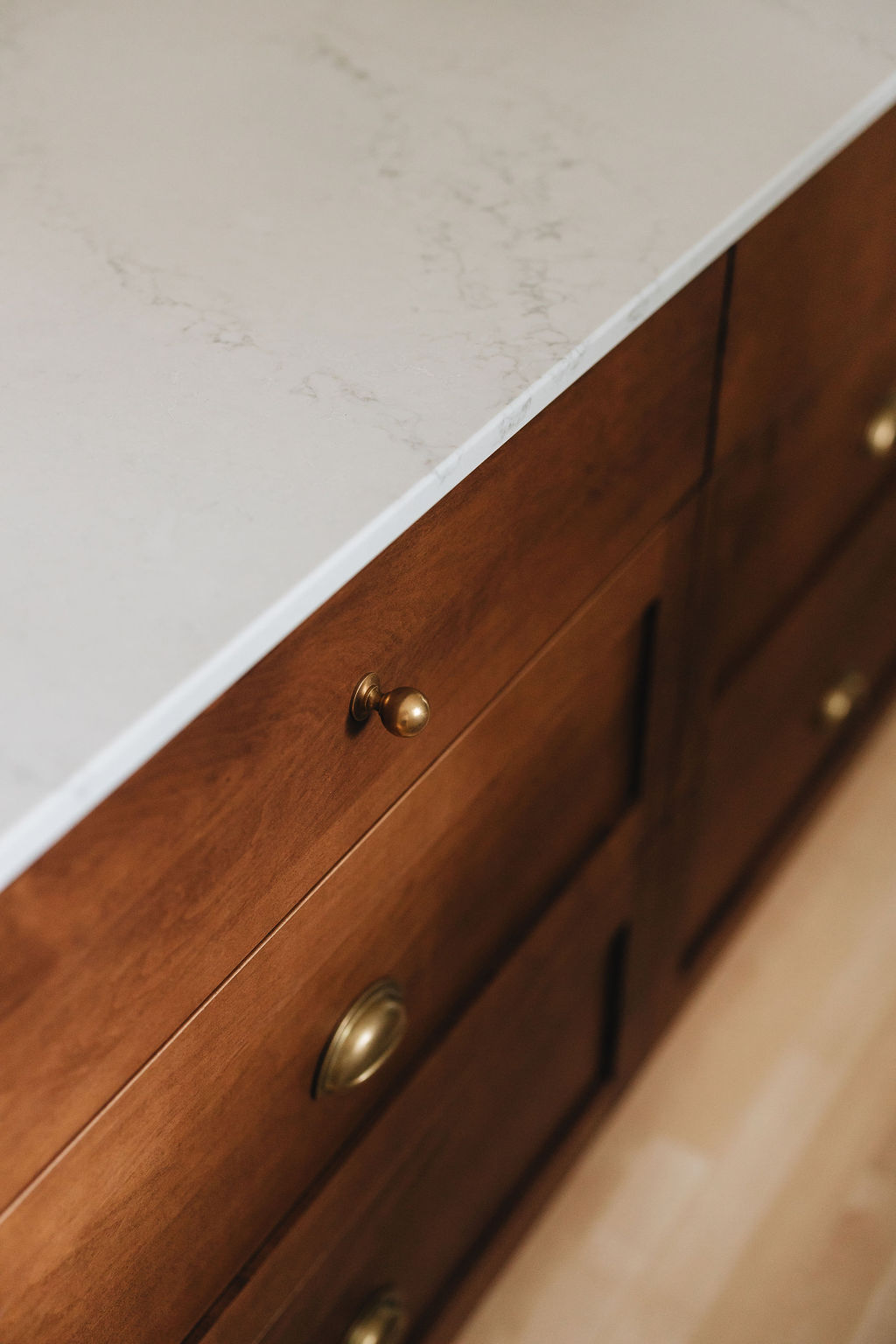 Comptoir de quartz et tiroirs en bois foncé, détail d’ébénisterie