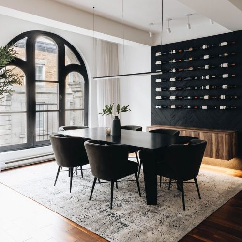 Salle à manger design avec mur cave à vin et grande fenêtre arquée — rénovation résidentielle Montréal